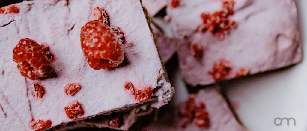 Tranche de parfait glacé aux framboises dressée avec framboises fraîches et menthe