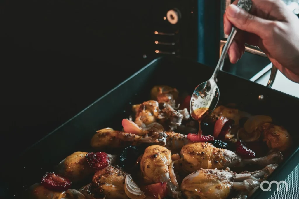 Poulet rôti arrosé de son jus à mi-cuisson dans le plat au four