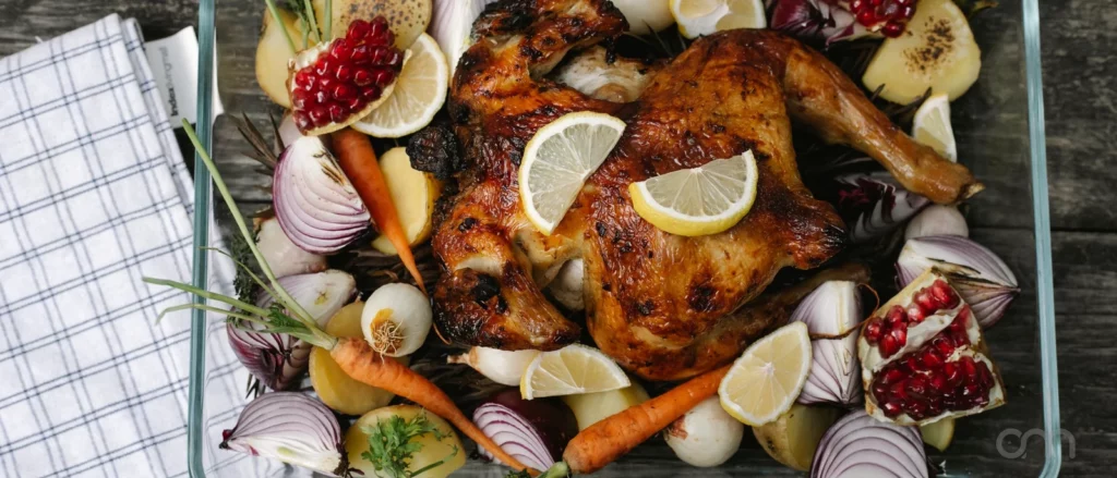 Poulet fermier rôti doré, pommes grenaille et légumes racines dans un plat