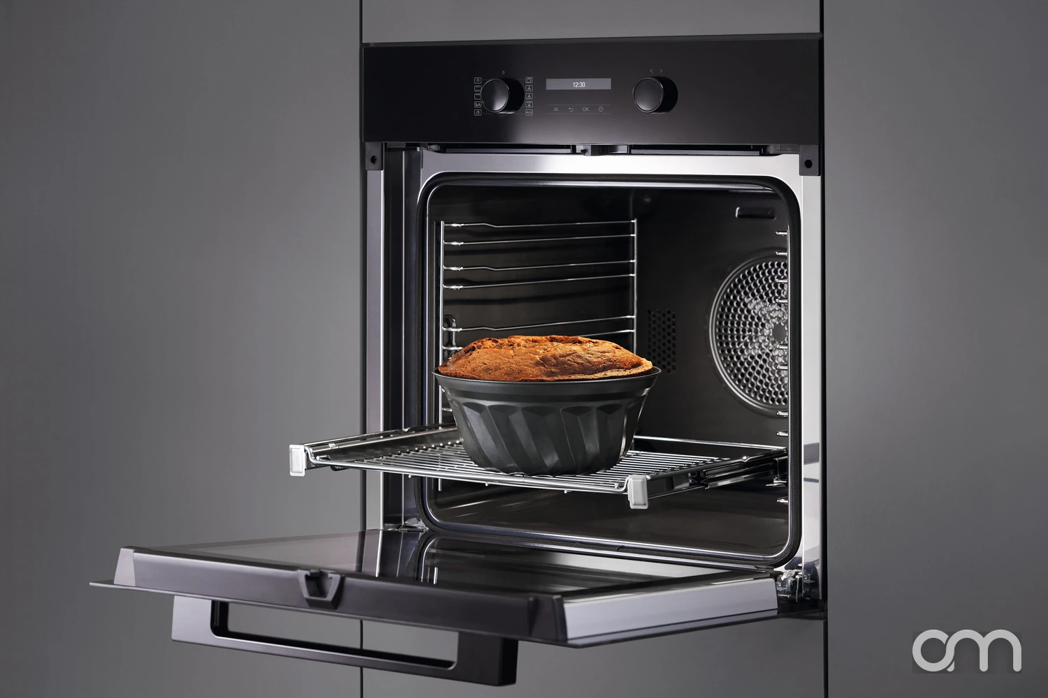 Intérieur d'un four encastrable Miele ouvert : gradins latéraux, émail sombre et ventilateur de chaleur tournante au fond de la cavité