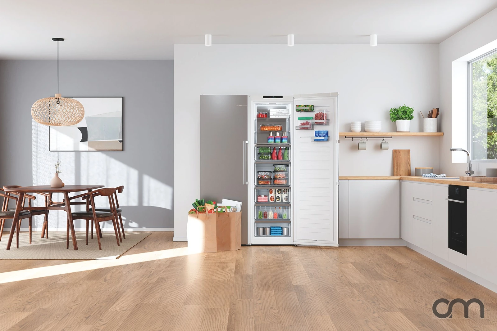 Congélateur pose libre Bosch ouvert, tiroirs et balconnets de porte remplis de provisions, à côté d'un réfrigérateur inox dans une cuisine claire : congélateurs livrés et installés par Arts & Ménagers, Neuchâtel
