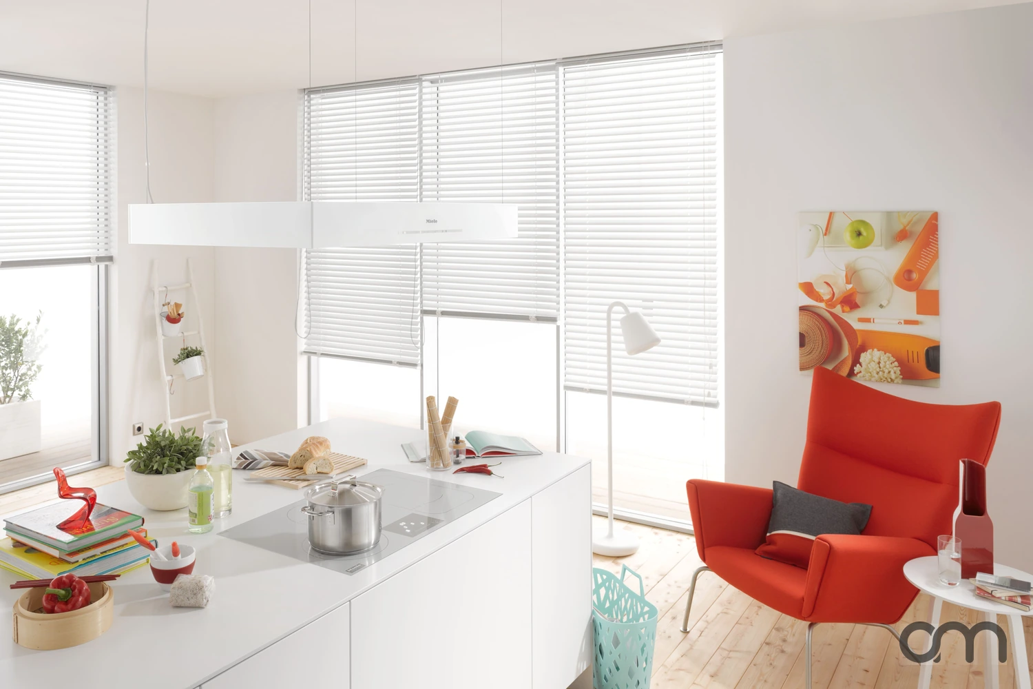 Hotte îlot Miele suspendue au-dessus d'un plan de cuisson dans une cuisine ouverte lumineuse, canton de Neuchâtel