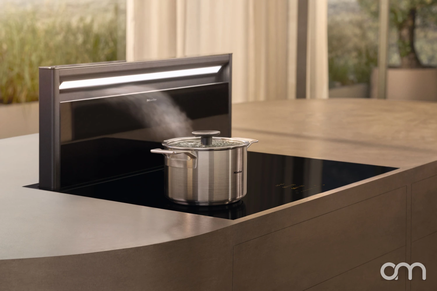 Hotte de plan de travail Miele escamotable captant la vapeur d'une casserole posée sur un plan à induction, cuisine contemporaine