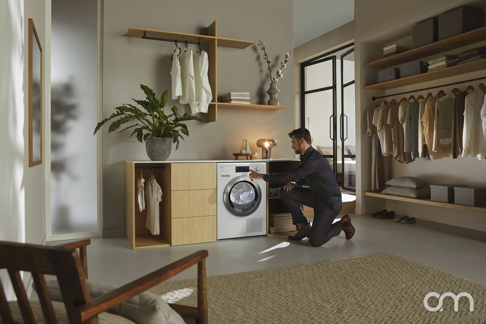 Homme utilisant un sèche-linge Miele T1 dans une buanderie, préparer les appareils de buanderie au gel en hiver dans le canton de Neuchâtel
